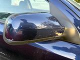 reflection of a man in a car mirror on the side of a car