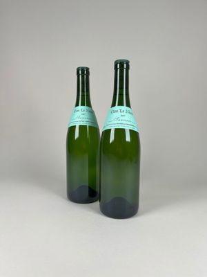 two bottles of wine sitting on top of a table next to each other