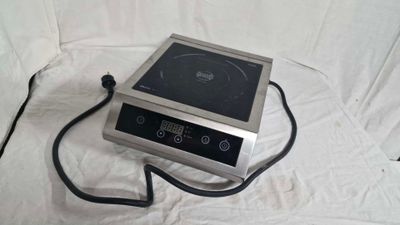 une photo d'une petite cuisinière électrique posée sur un drap blanc