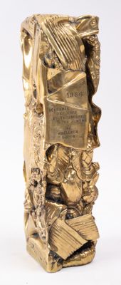 a gold statue of a man holding a book