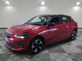 a red car is parked on a checkered floor in a showroom