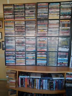 une grande collection de DVD rangée sur une étagère dans une pièce
