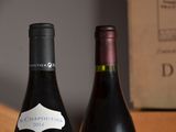 two bottles of wine sitting next to each other on a table