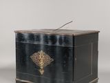 an old black chest with a gold decoration on the front