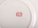 a white plate with a red flower on it