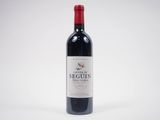 a bottle of red wine sitting on top of a white table