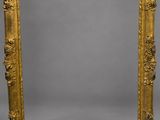 an ornate gold framed mirror on a grey background