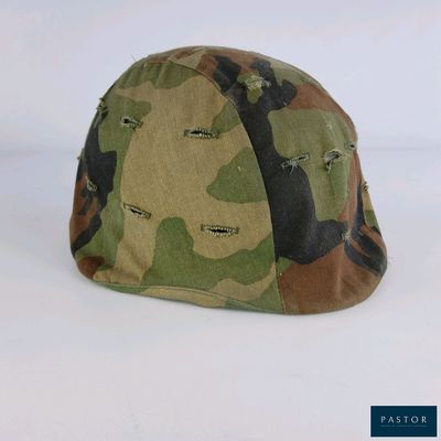 un gros plan d'un casque de camouflage posé sur une surface blanche