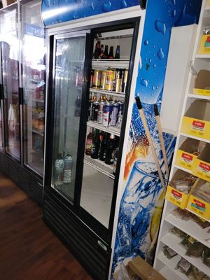 a refrigerator in a store with a lot of drinks on the shelves