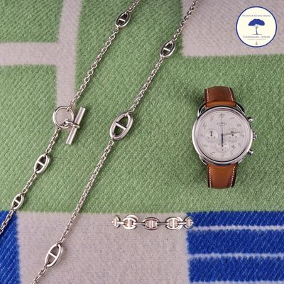 a watch and a chain on a blanket
