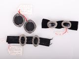 trois pièces de velours noir et des bijoux en argent sur une surface blanche