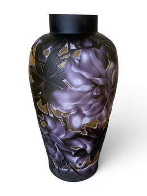 un vase orné de fleurs violettes sur fond blanc
