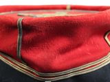 a close up of a red and black hat with gold trim