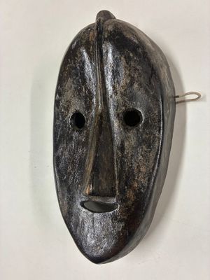 une image d'un masque en bois accroché au mur