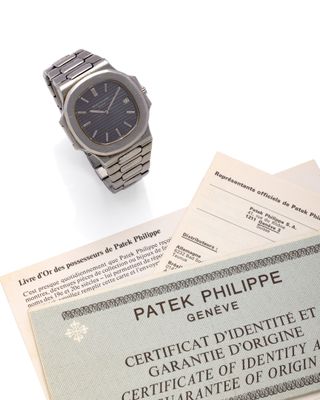 a wrist watch and a certificate sitting on top of a table