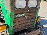 a green tractor that is parked in the parking lot