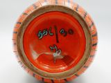 a small orange bowl with a clock on it