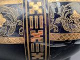 a blue vase with a gold design on it