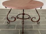 a small table with a red top on a brick floor