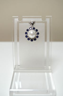 Un pendentif en argent serti au centre d'une perle de cultur…