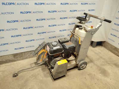 un gros plan d'une machine posée sur un sol en béton, devant un mur