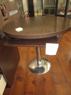 une table ronde avec un piètement en métal dans une pièce
