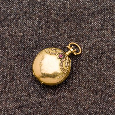 une montre de poche en or sertie d'une pierre rose