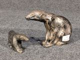 deux figurines représentant un ours et son ourson, posées sur un tapis