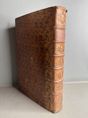 an old book sitting on top of a table next to a wall
