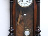 a clock hanging on the wall with a pendulum on it