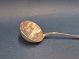 a silver spoon with a handle on a blue surface