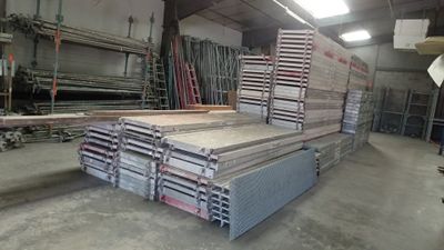 a large pile of wood in a warehouse with a lot of pallets