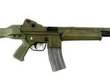 un pistolet-jouet muni d'un chargeur, posé sur une surface blanche