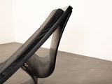 a black chair that is sitting on a concrete floor