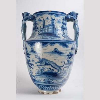 un grand vase bleu et blanc posé sur un socle