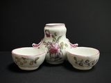 three bowls and a vase sitting on a table