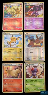 Plusieurs cartes Pokémon sont alignées sur une surface noire