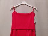 red dress hanging on a hanger against a white wall