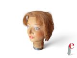 une tête de mannequin aux cheveux roux et aux yeux bleus
