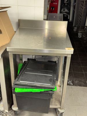 une table en métal sur laquelle se trouvent une poubelle et une boîte