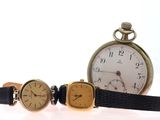 three different types of watches sitting next to each other on a white surface