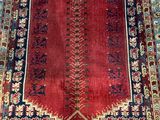 a red and blue rug with a floral design on it