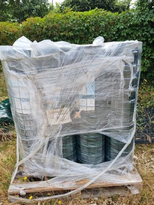 de nombreux rouleaux de fil métallique emballés dans du plastique sur une palette