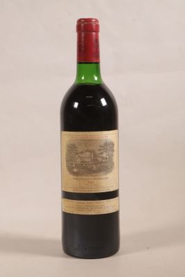 une bouteille de vin rouge posée sur une table blanche