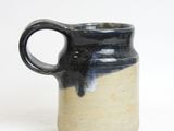 a black and white mug with a handle on a white surface