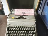 an old typewriter sitting on top of a table next to a blue box