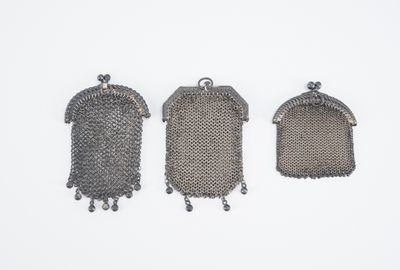 trois sacs à main anciens en maille métallique argentée sur fond blanc