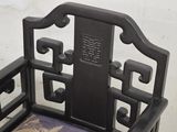 a black chair with a purple cushion on it