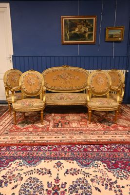 un canapé et trois fauteuils dans une pièce recouverte d'un tapis