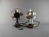 two metal fans that are sitting on a table